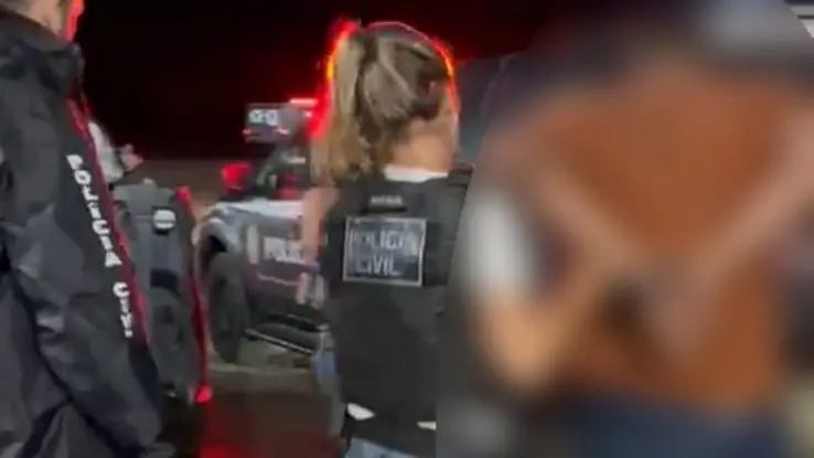 prisao homem feminicidio mulher loira policial levando algemado maos para tras.