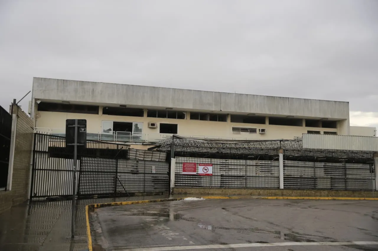 Com visíveis sinais de abandono e desgaste, antigo terminal do Aeroporto está cercado por portões metálicos.