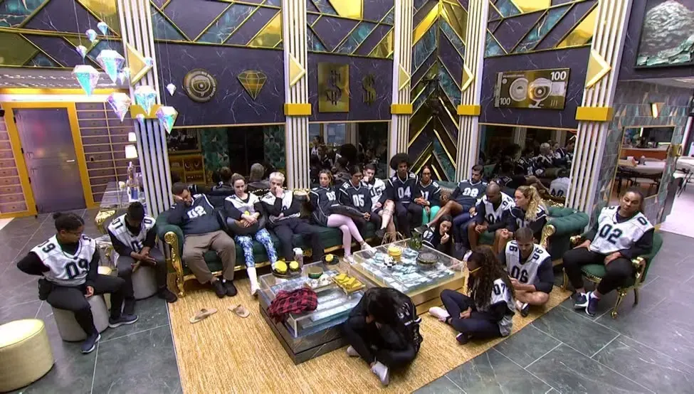 Participantes do BBB 26 sentados na sala da casa.