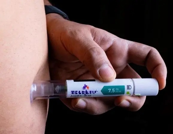 mão de homem aplicando caneta emagrecedora em área na barriga.