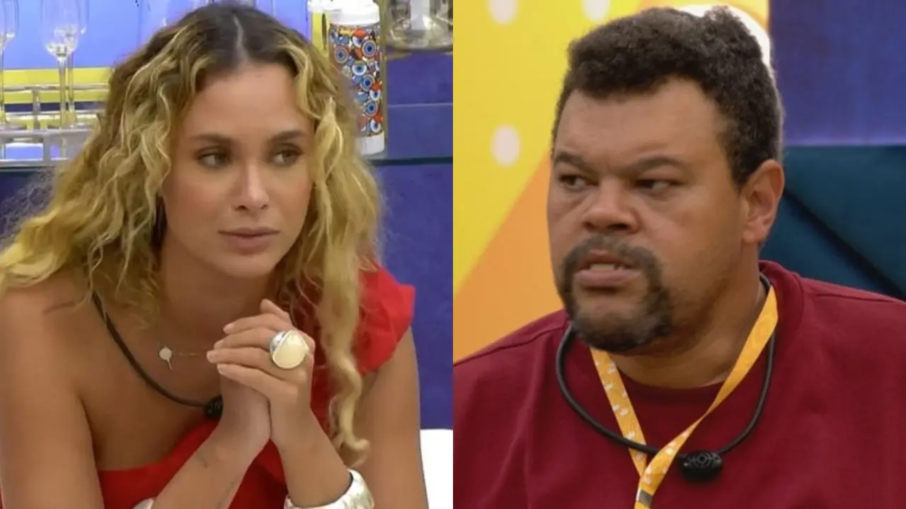 Duas pessoas aparecem em ambientes internos distintos de um programa de TV. À esquerda, uma mulher com cabelos longos e ondulados, usando um vestido vermelho e acessórios prateados, está sentada com as mãos juntas sobre a mesa. À direita, um homem com camiseta vermelha e um cordão amarelo no pescoço está sentado em frente a uma parede colorida.