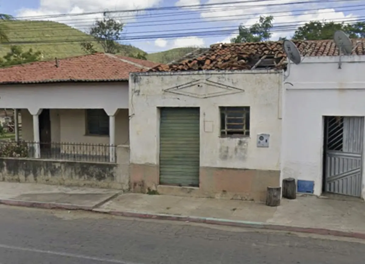 Casa geminada com uma porta de ferro de correr e uma pequena janela.
