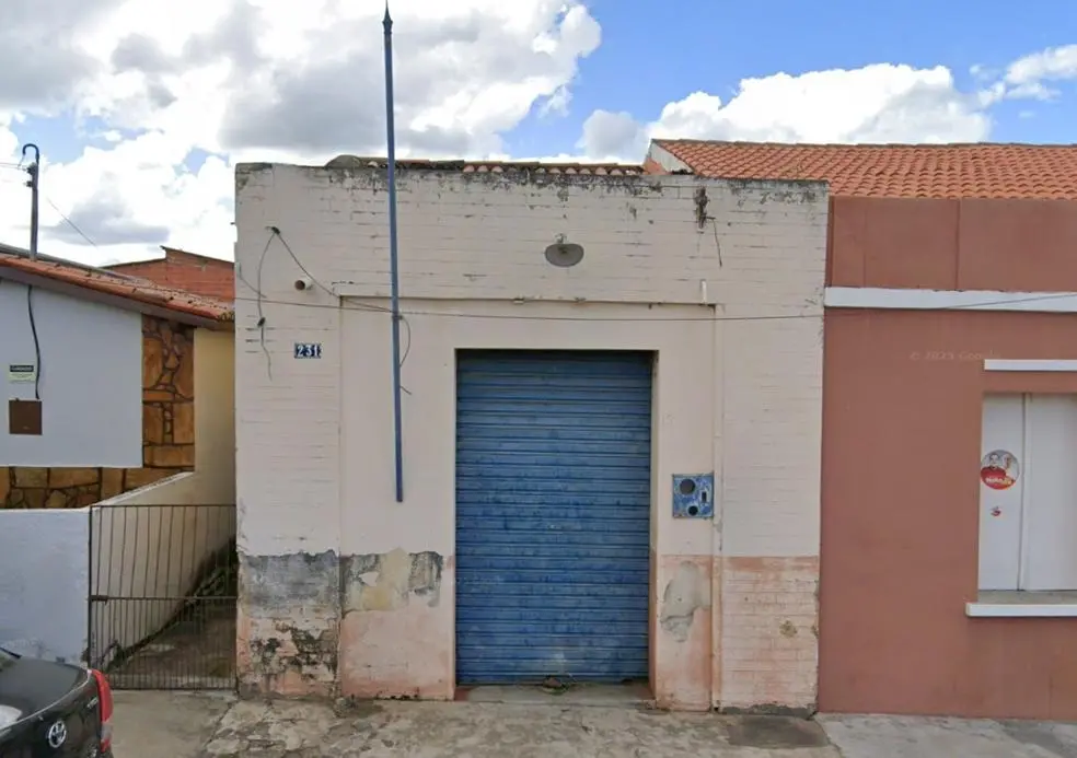 Casa comercial geminada de apenas uma porta de correr de ferro.