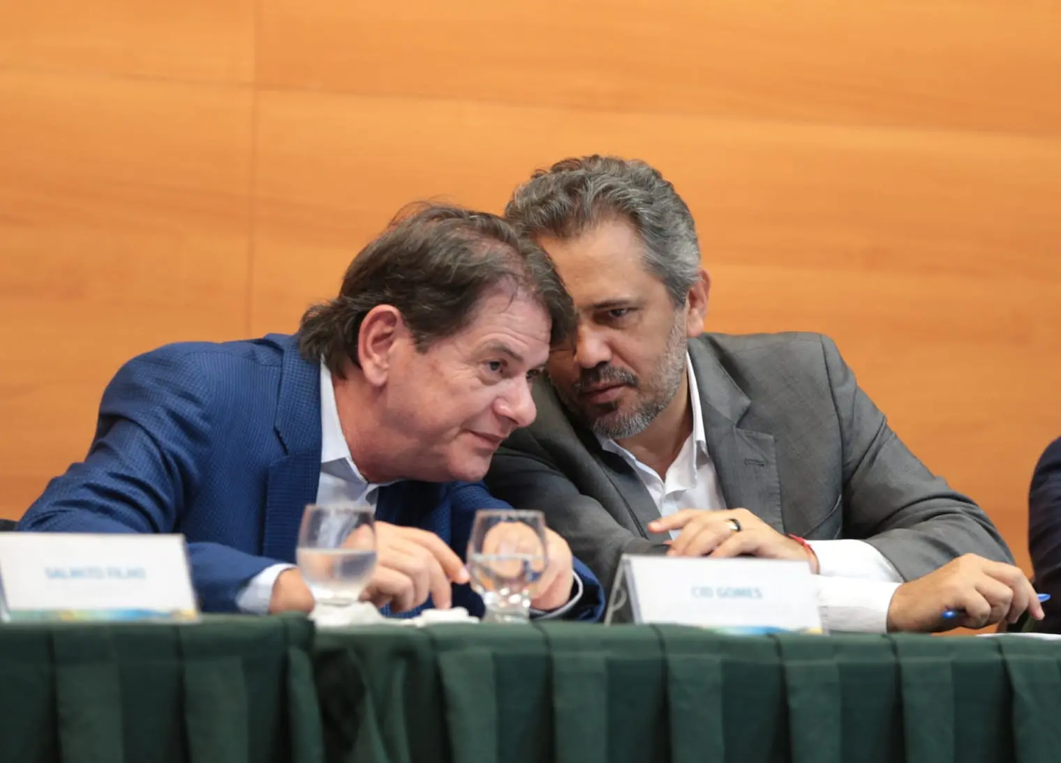 Elmano de Freitas e Cid Gomes conversando. Ambos estão sentados.