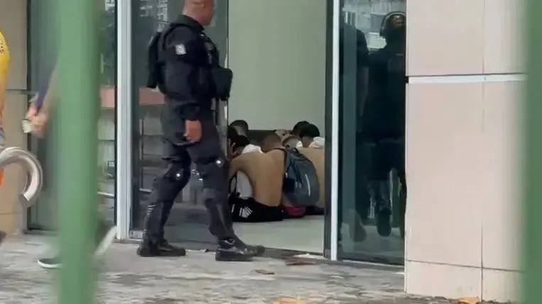 homens presos em delegacia, policial em pe.