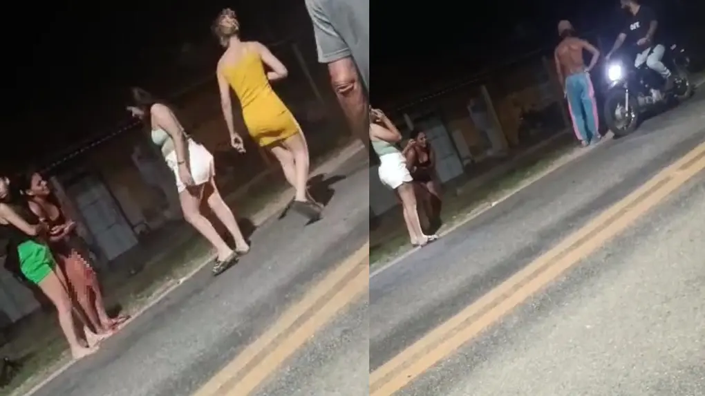 Imagem de uma rua à noite com várias pessoas, incluindo uma mulher de vestido amarelo e outras em grupos, com alguns indivíduos ao lado de uma moto.