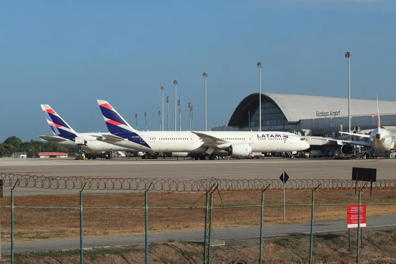 imagem mostra dois aviões de grande porte da latam estacionados no aeroporto de fortaleza.