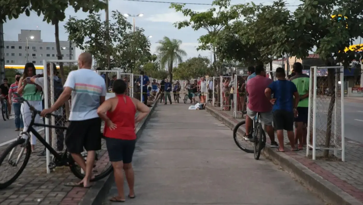 Imagens de pessoas olhando o corpo de uma vítima na ciclovia da avenida alberto craveiro, bairro Dias Macedo.