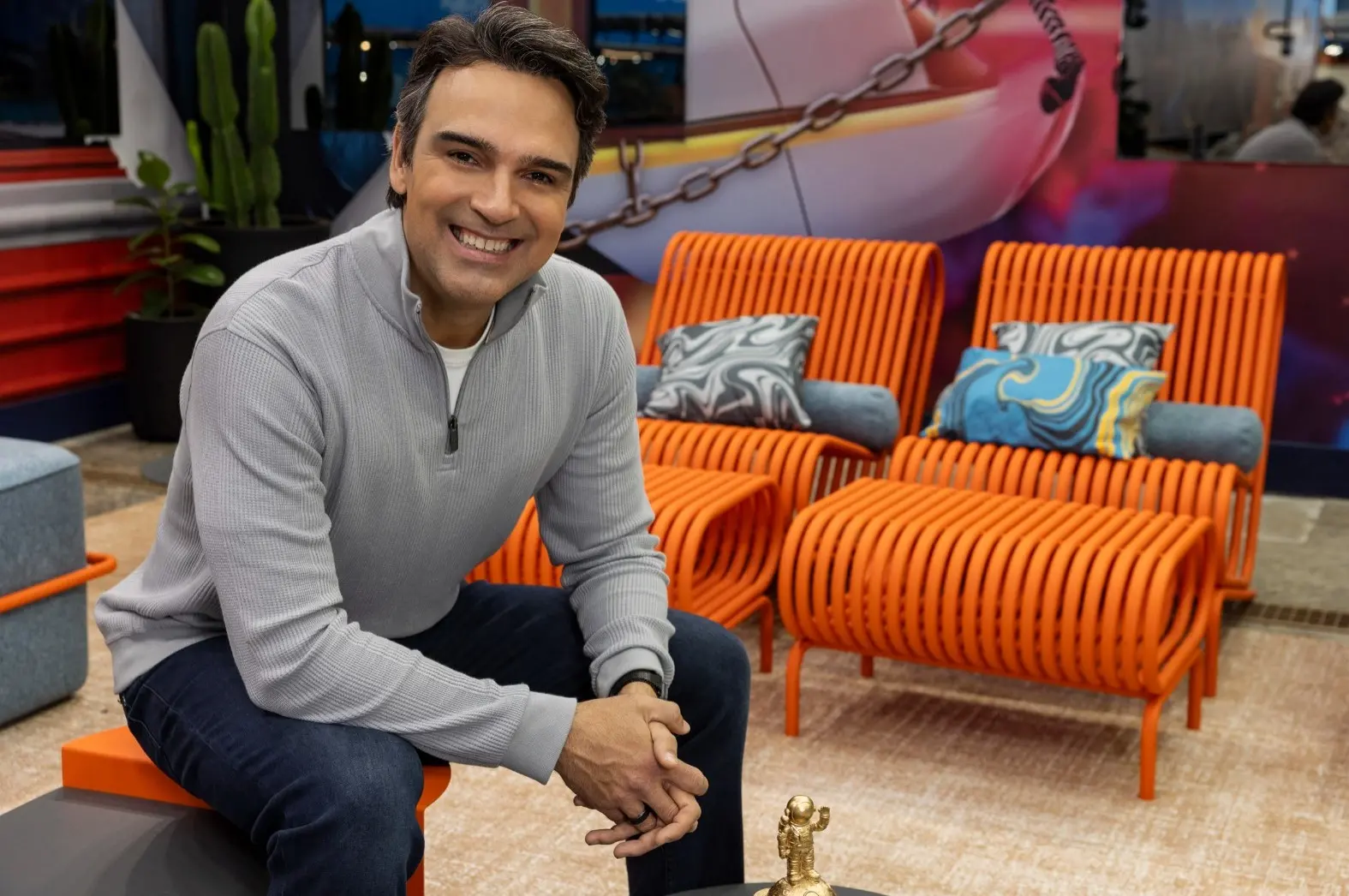 Tadeu Schmidt sentado na área de descanso do BBB 26.