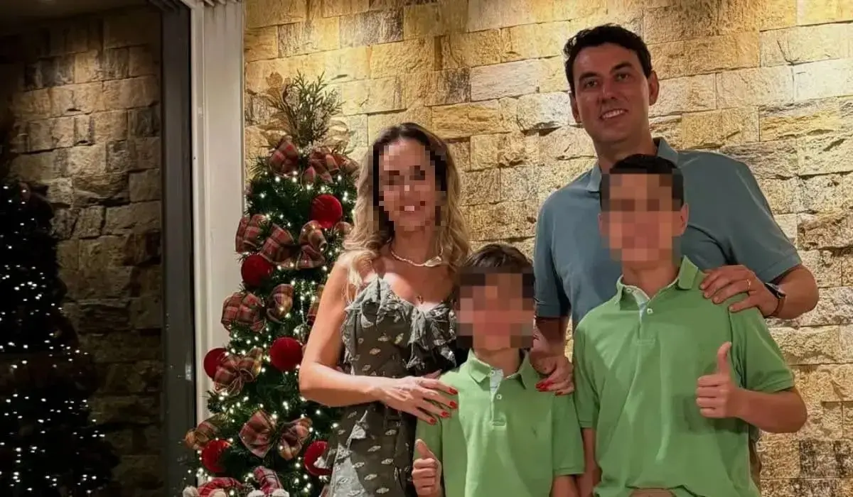 Família do secretário de Itumbiara posando para foto em ambiente decorado para o Natal, com árvores iluminadas, enfeites vermelhos e parede de pedra ao fundo. Thales Naves Machado, que atirou e matou os dois filhos.