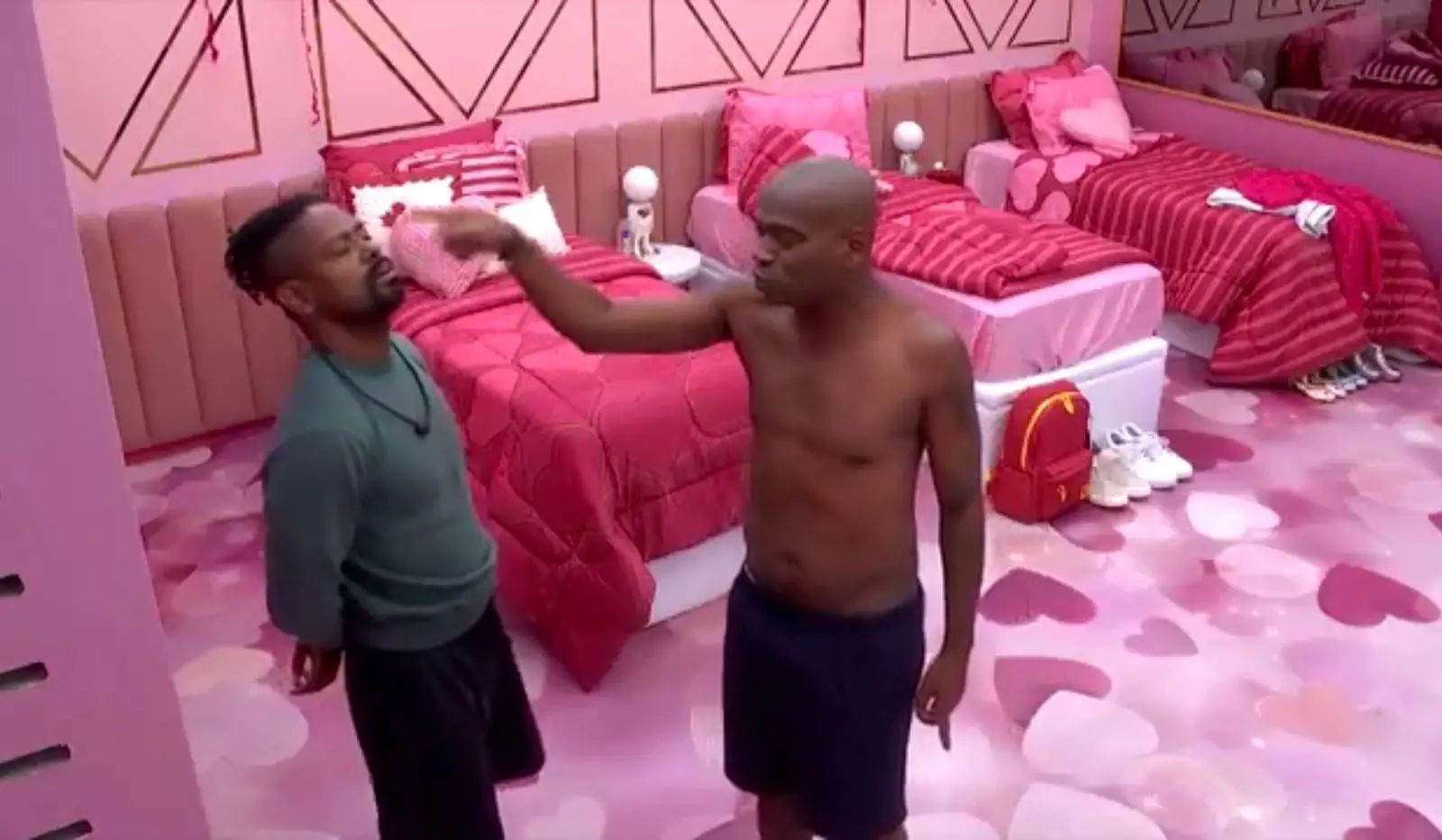 Edilson e Leandro discutindo enquanto um aponta o dedo na cara do outro, que se esquiva.