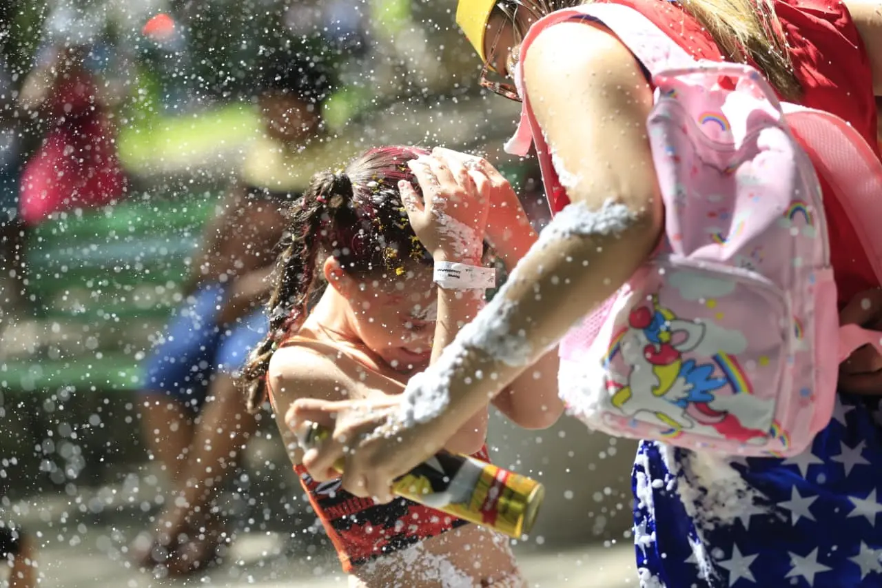 Crianças enfeitada para Carnaval coberta de espuminha.