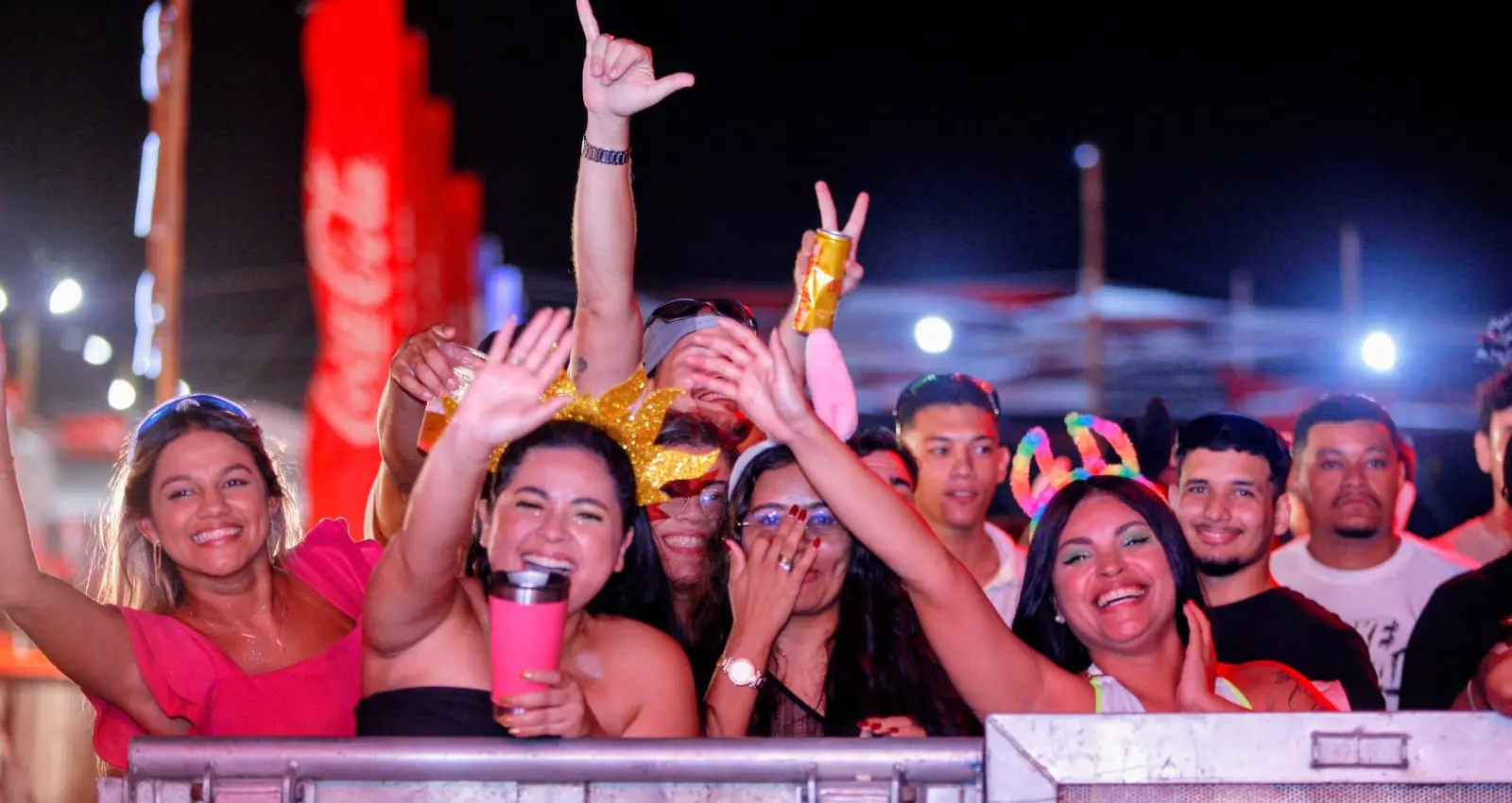Pessoas curtindo o carnaval de Aquiraz perto da grade que separa o palco.