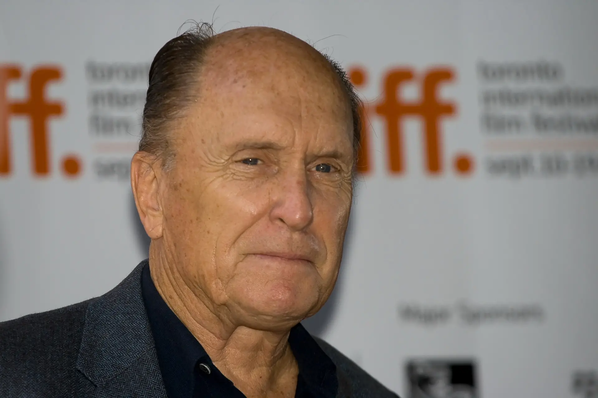 Ator Robert Duvall de perfil, calvo e com rugas, vestindo terno escuro. Ao fundo, um letreiro do festival de cinema de Toronto, em 2009.