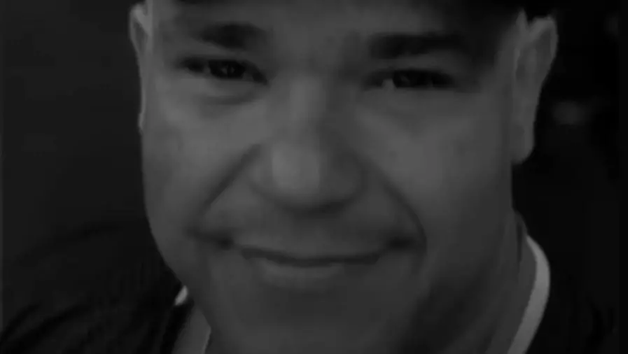 Foto em preto e branco de Fabrício Costa, um homem de meia idade e de barba rala.