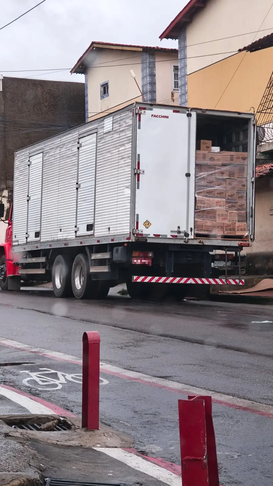 Caminhão parado com traseira aberta cheia de caixas.