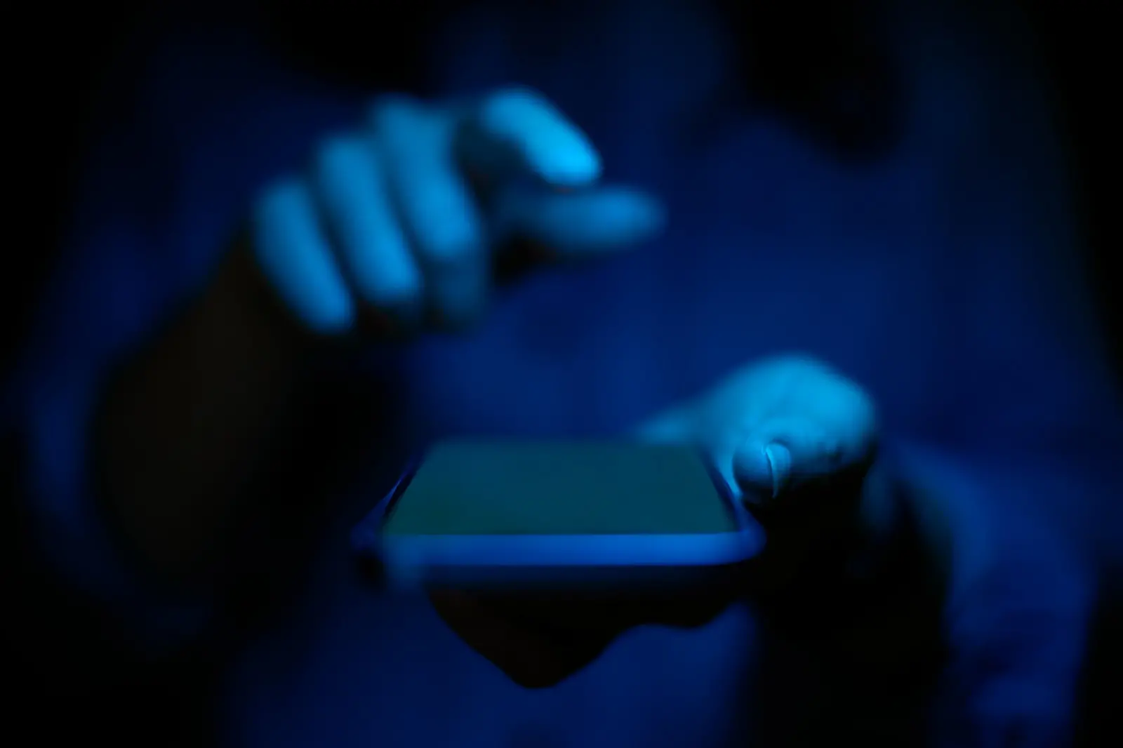 celular homem segurando misterio luz azul.