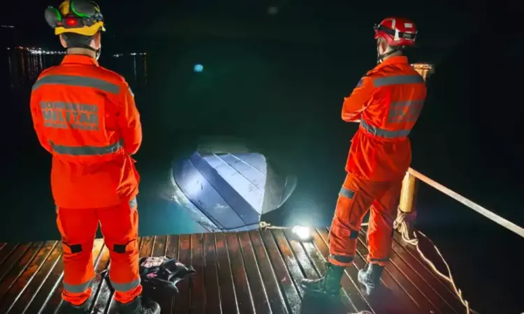 Dois agentes do Corpo de Bombeiros de MG observam a embarcação após o acidente.
