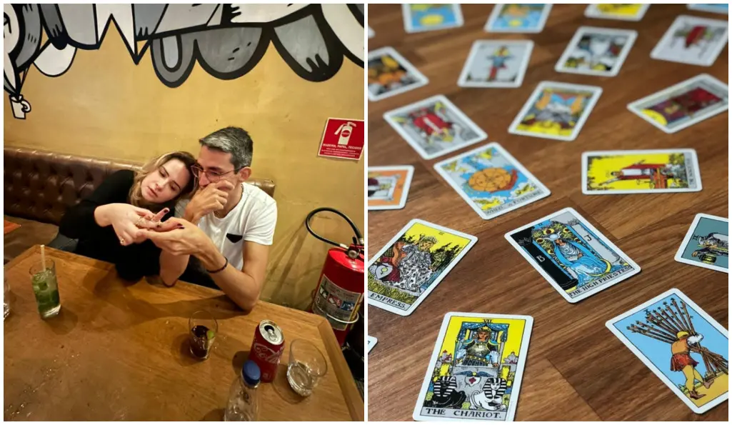 Duas pessoas sentadas lado a lado em uma mesa de bar, inclinadas para frente enquanto observam algo que seguram juntas nas mãos; sobre a mesa há copos, uma lata de refrigerante, um copo com bebida verde e outros objetos. A parede ao fundo tem um grafite em preto e branco e um extintor de incêndio está posicionado ao lado da mesa. Ao lado, em outra imagem, várias cartas de tarô coloridas estão espalhadas sobre uma mesa de madeira, incluindo cartas como The Chariot e outras figuras tradicionais do baralho.