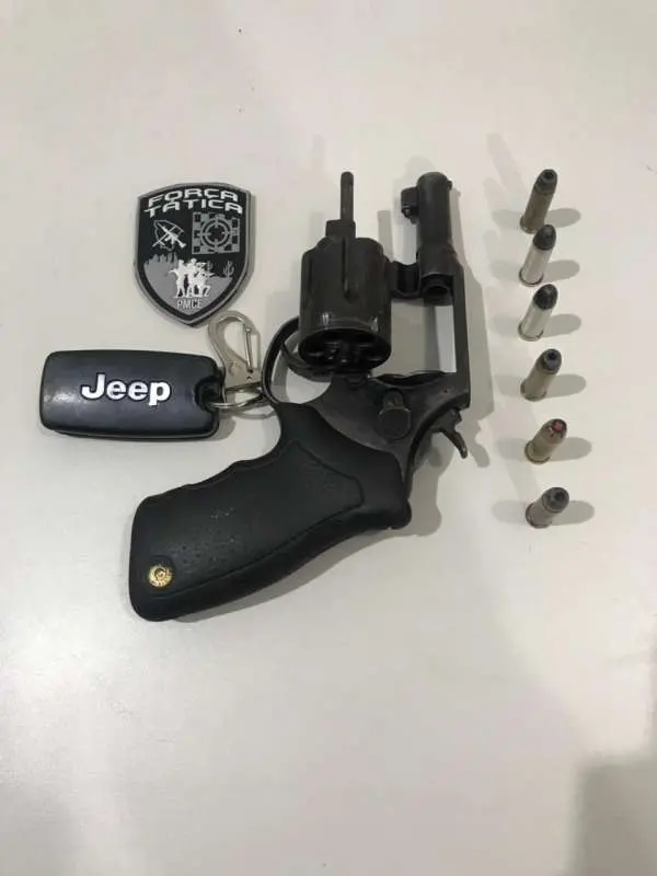 foto de balas, arma de fogo, chave de um carro jeep.