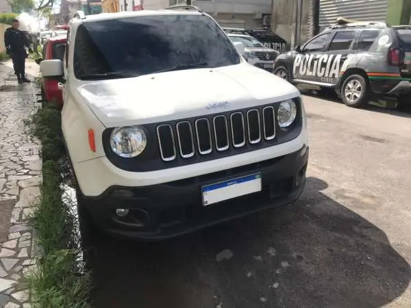 veiculo jeep cor branca em uma rua.
