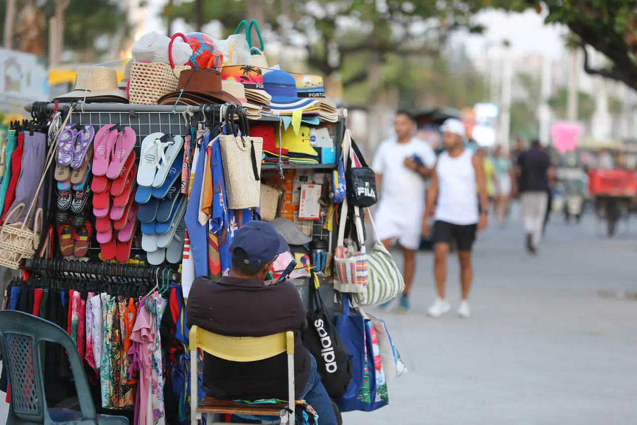 Foto de trabalhador informal na orla de Fortaleza.