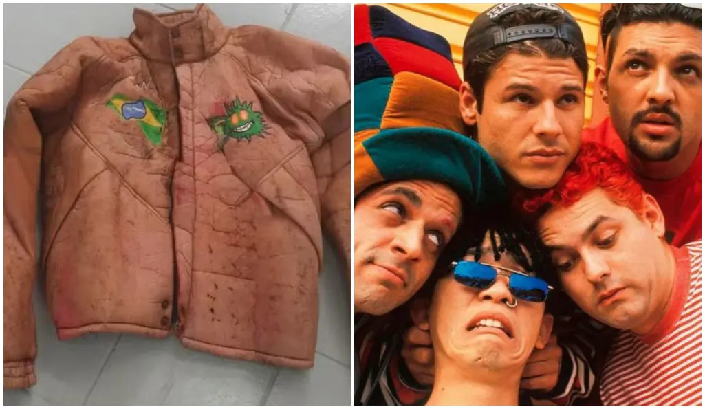Montagem com duas imagens lado a lado. À esquerda, uma jaqueta acolchoada de cor marrom‑clara, visivelmente desgastada e manchada, exibindo dois emblemas coloridos: um com a bandeira do Brasil e outro com um desenho estilizado semelhante a um sol verde com expressão caricata. À direita, um grupo de pessoas posando juntas diante de um fundo colorido com listras vibrantes; partes da imagem estão cobertas por blocos retangulares que ocultam detalhes dos indivíduos.