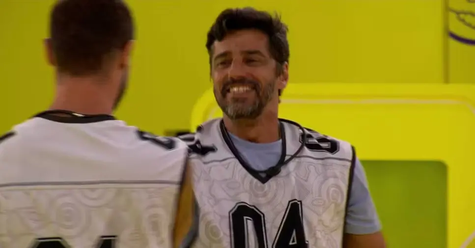 Imagem do participante Alberto Cowboy cumprimento o colega Jonas de costas.