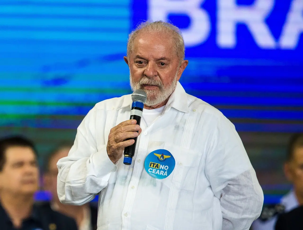 O presidente Lula, de camisa branca e com um adesivo escrito 