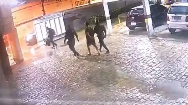 Imagem mostra homem levado preso por PMs, saindo de prédio, no bairro Papicu.