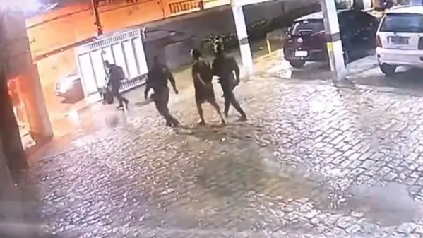 Imagem mostra homem levado preso por PMs, saindo de prédio, no bairro Papicu.