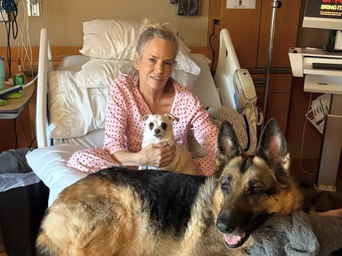 Jennifer Runyon em uma cama de hospital com seus cachorros.
