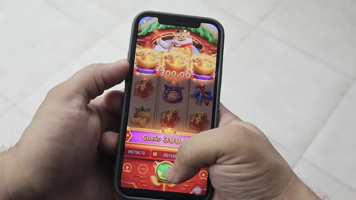 jogo do tigrinho, pessoa segurando celular, jogando.