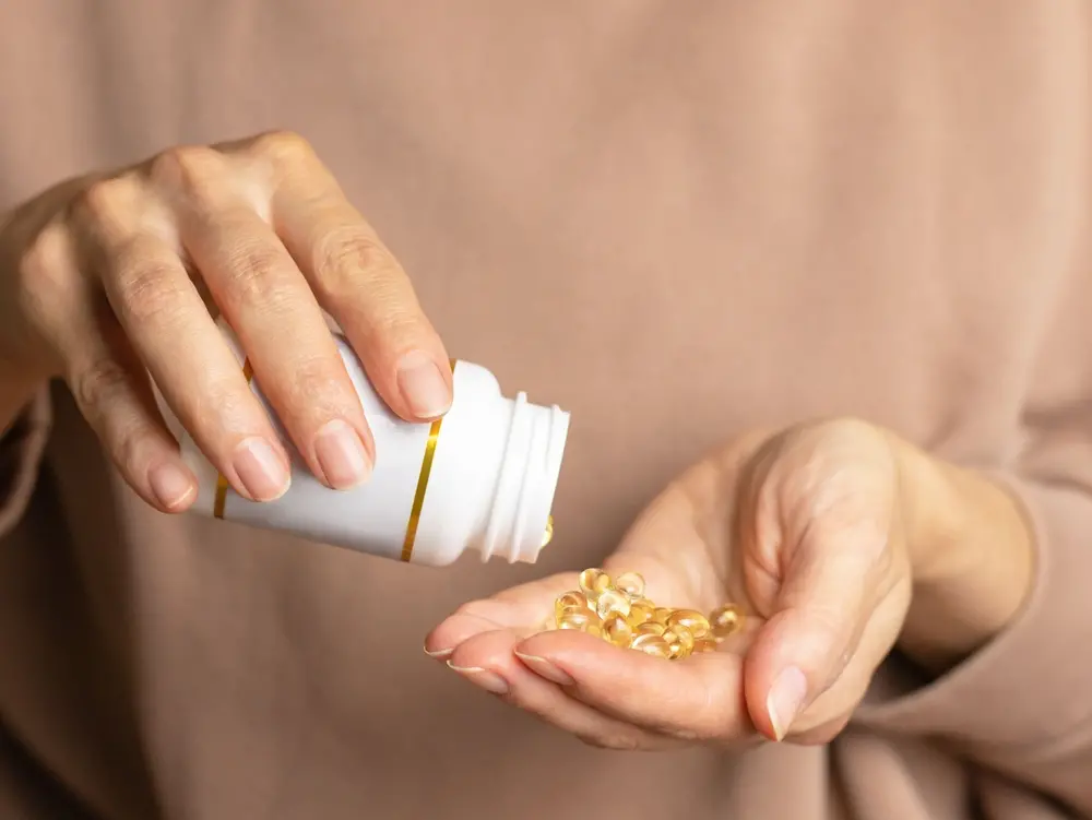 foto de mãos segurando embalagem plástica de cápsulas.