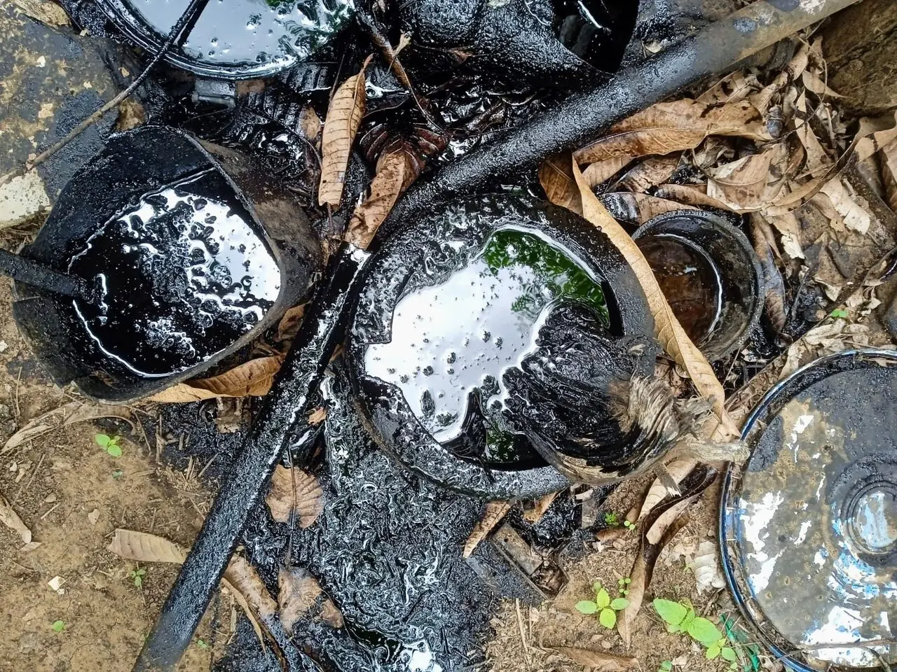 Imagem de potes com um líquido preto e viscoso.