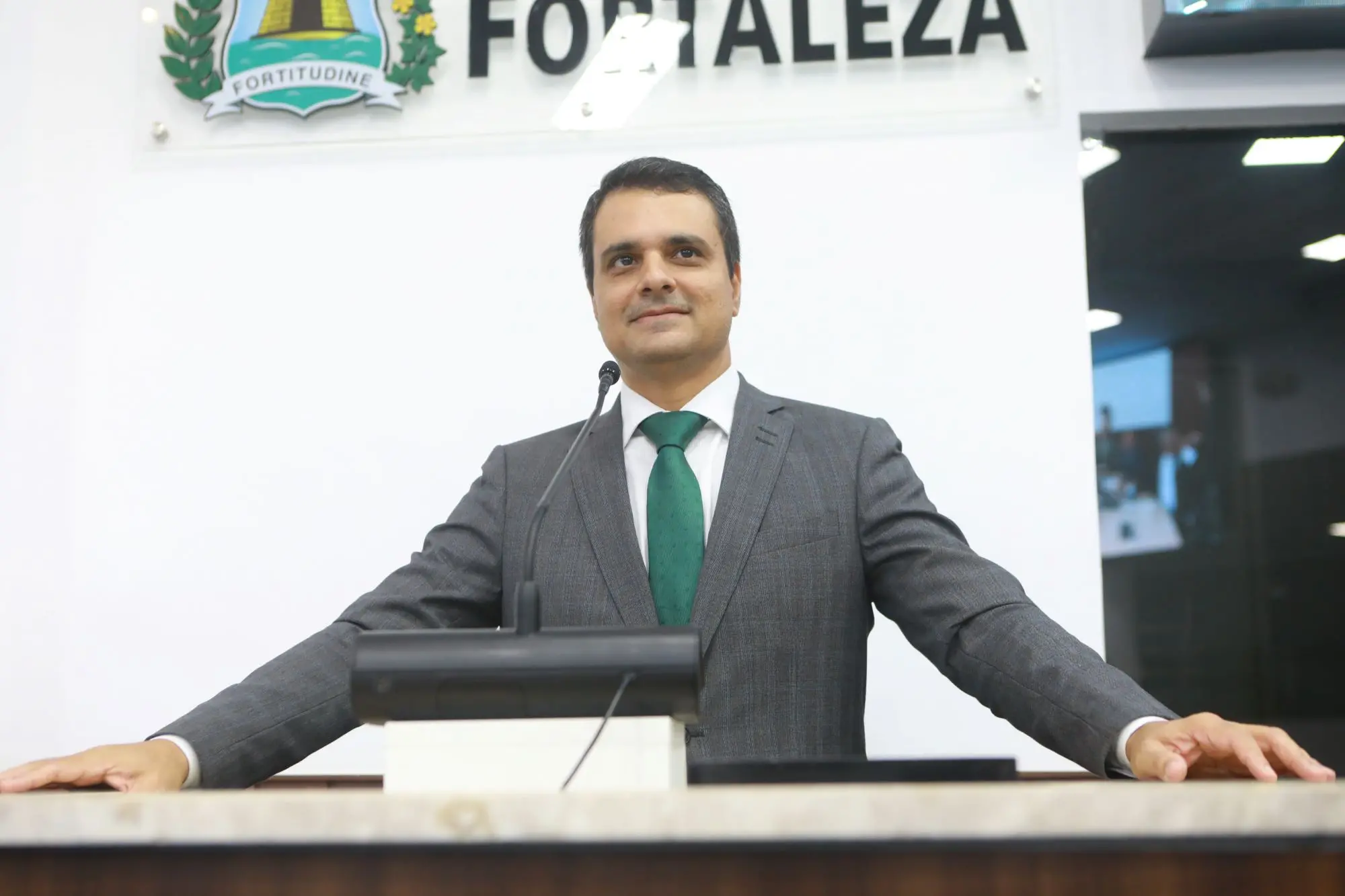 O vereador Gardel Rolim aparece no púlpito da Câmara de Fortaleza. Ele olha para o horizonte e sorri.