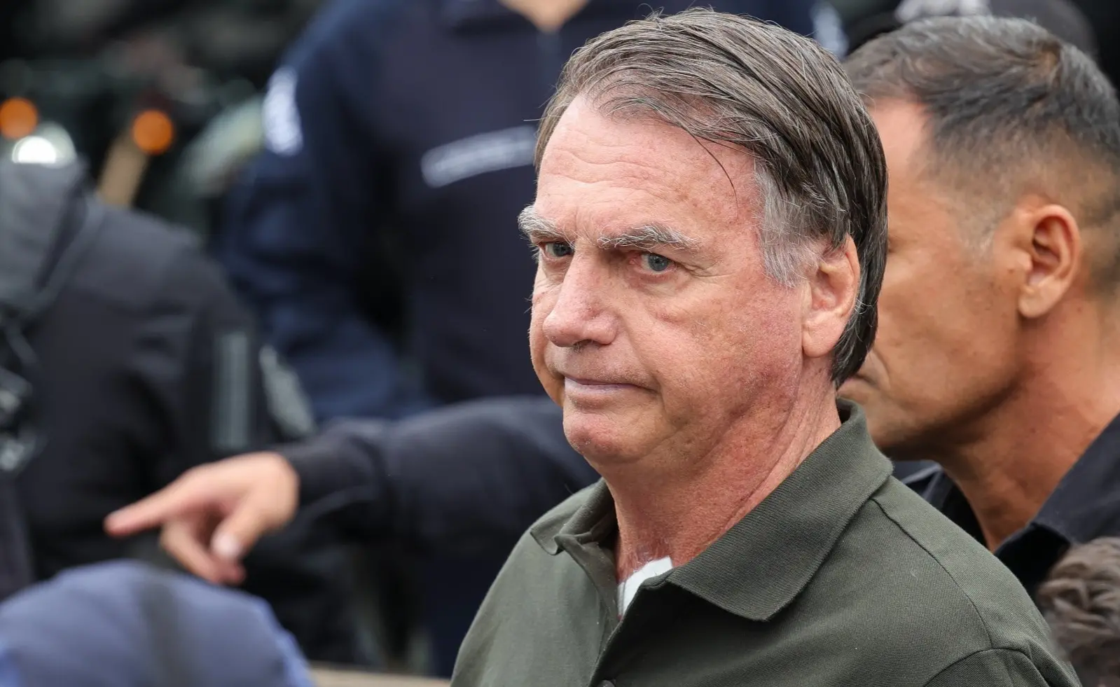 Jair Bolsonaro com expressão séria. Ele é um homem idoso, branco e de cabelo grisalho bem penteado para o lado.