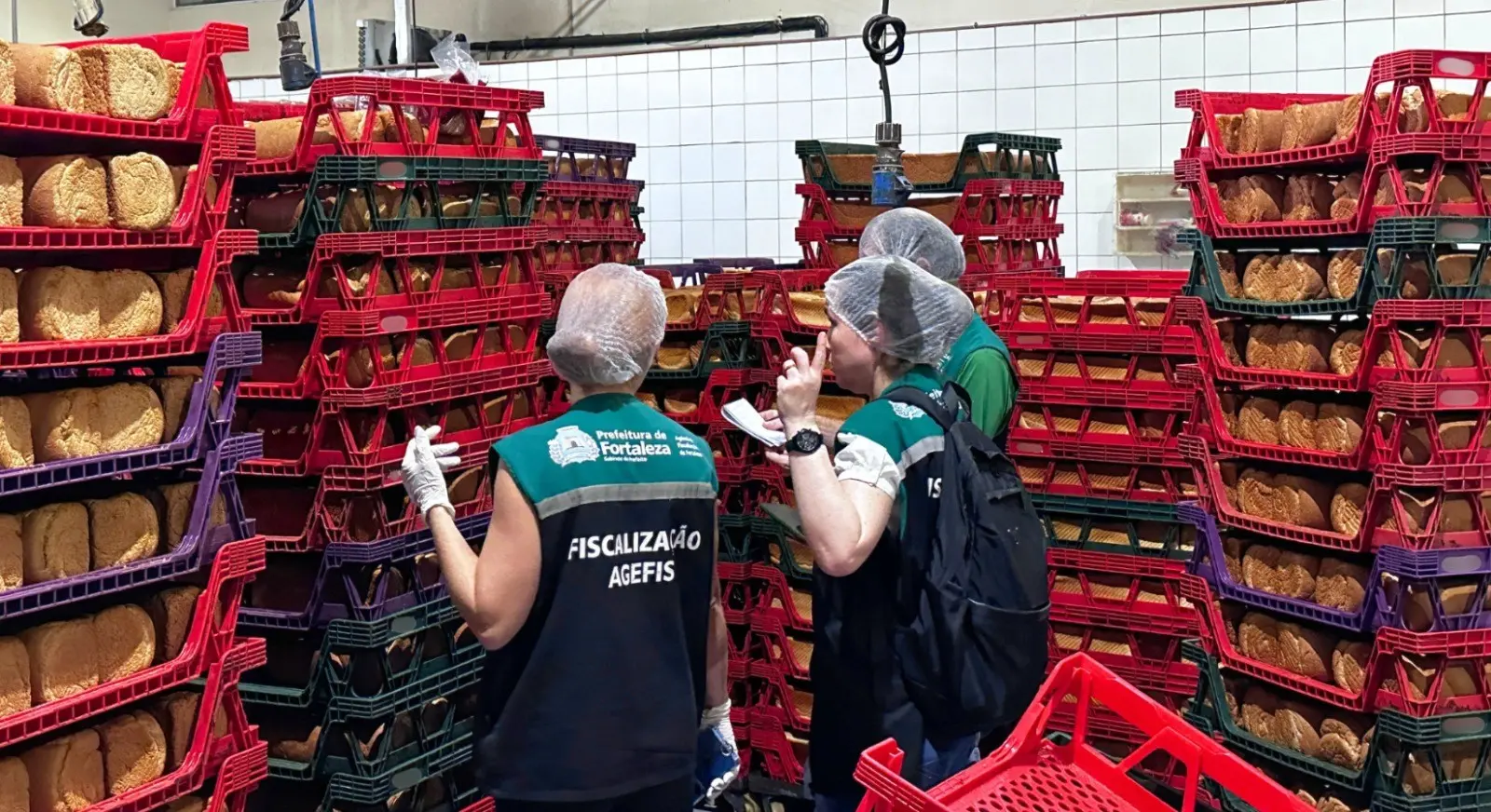 Imagens de agentes de fiscalização que interditaram um estabelecimento após infestação de baratas.