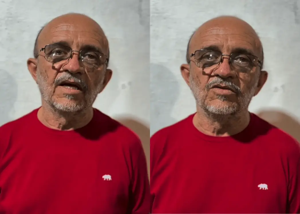 Homem idoso, careca, de barba e bigode grisalhos, usando óculos e uma camiseta vermelha com pequeno logotipo branco no peito, aparece em duas imagens lado a lado. Ele está de frente para a câmera, com expressão séria, diante de uma parede clara e lisa ao fundo.