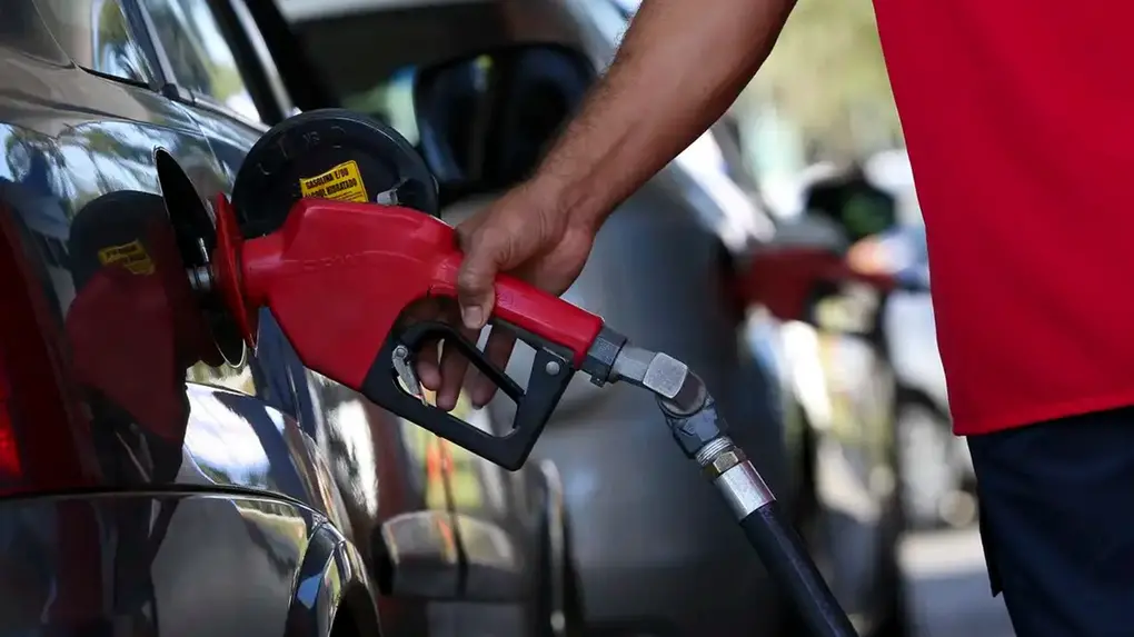 Foto de carro sendo abastecido em posto de combustíveis.