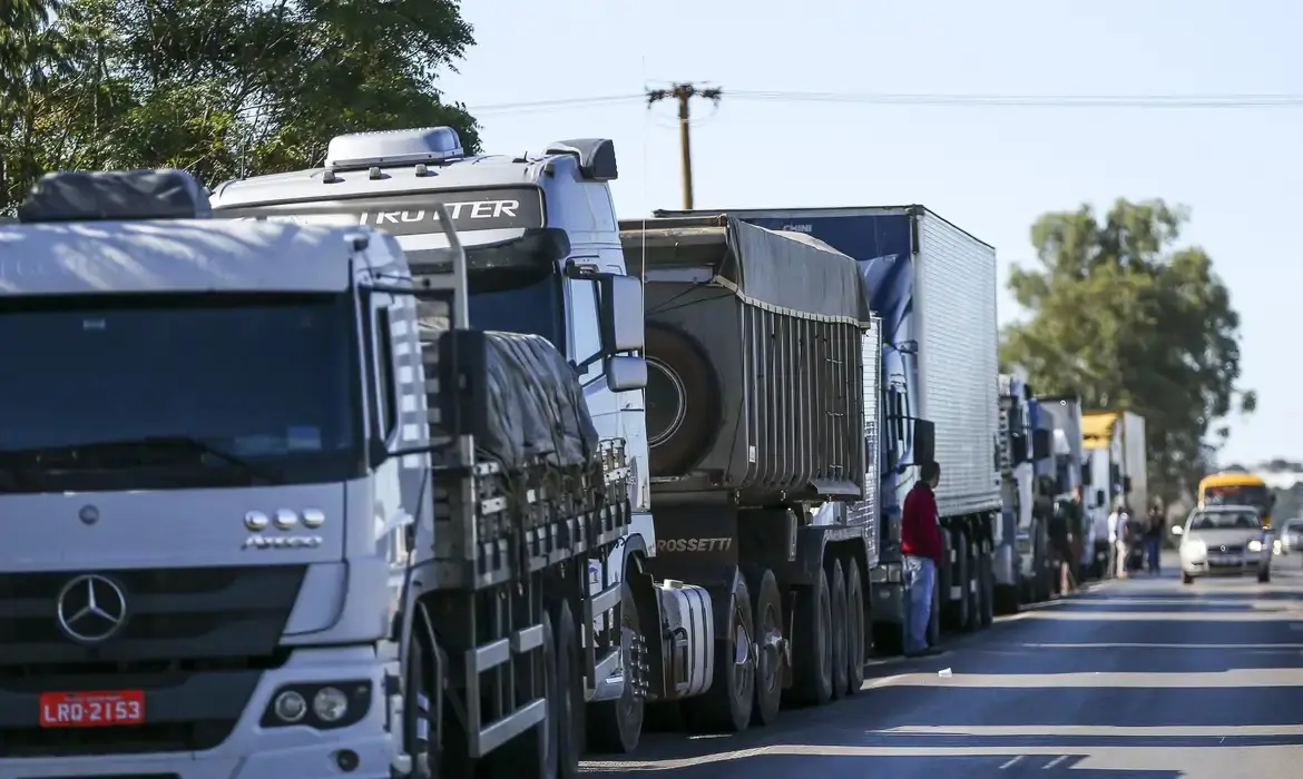 Foto que contém caminhões parados durante greve dos caminhoneiros no Brasil em 2018.