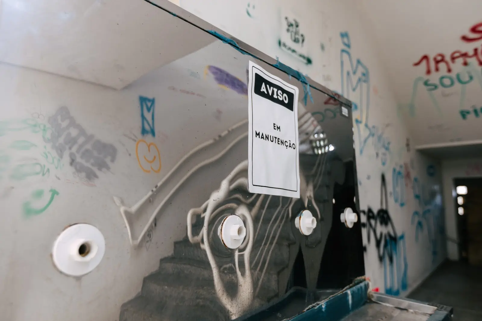 Imagem mostra bebedouro do Instituto de Educação Física e Esportes (Iefes) da UFC com placa de manutenção.