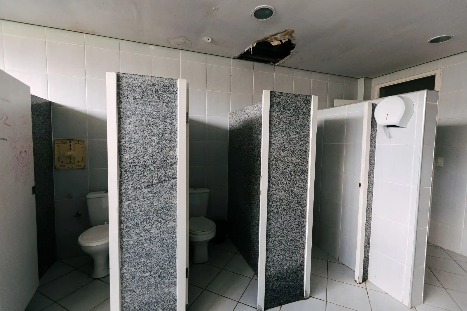 Imagem mostra banheiro do Instituto de Cultura e Arte (ICA), da UFC, com buraco no teto.