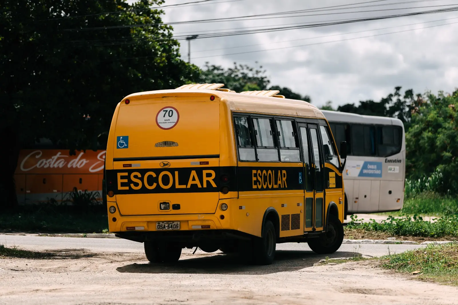 Imagem mostra micro-ônibus com escrito escolar que atua no transporte de alunos da UFC.