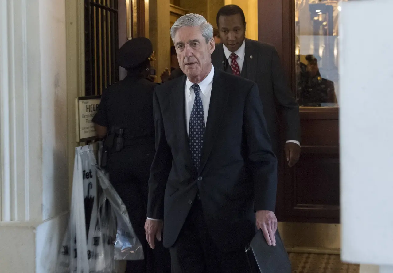 Robert Mueller, ex-diretor do FBI, saindo de uma porta de um tribunal com uma pasta preta na mão.