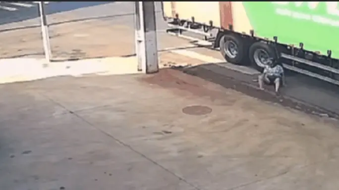 Imagem mostra hora que mulher se salva de acidente com caminhão rolando pela via.