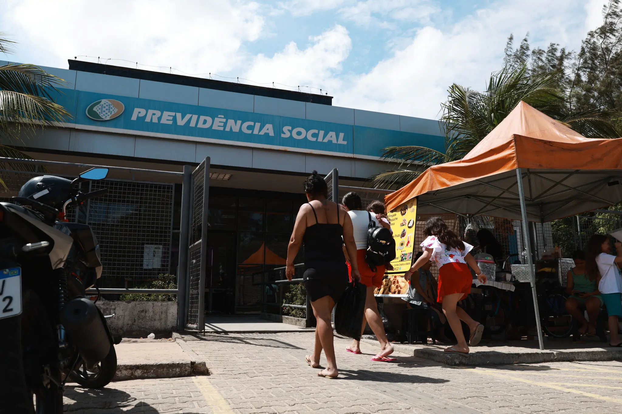 Pessoas entrando em agência da previdência social.