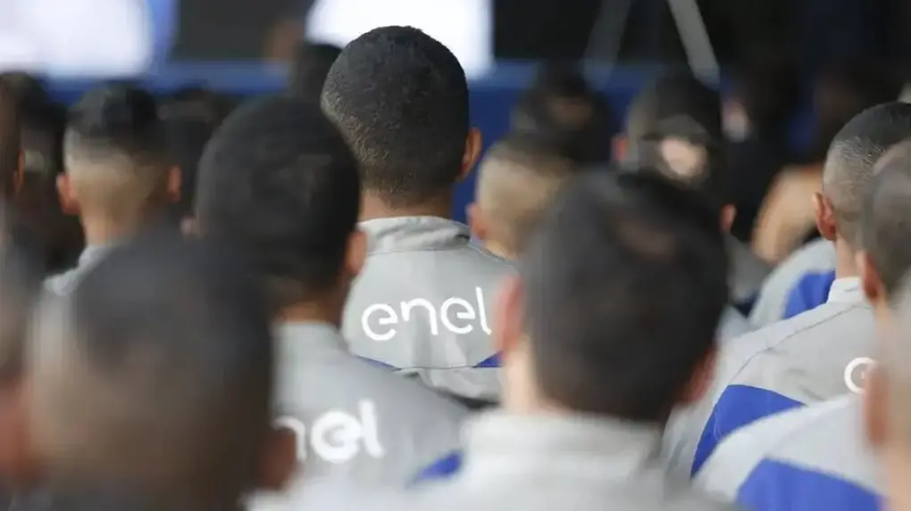 Colaboradores uniformizados com roupa com símbolo da Enel nas costas.