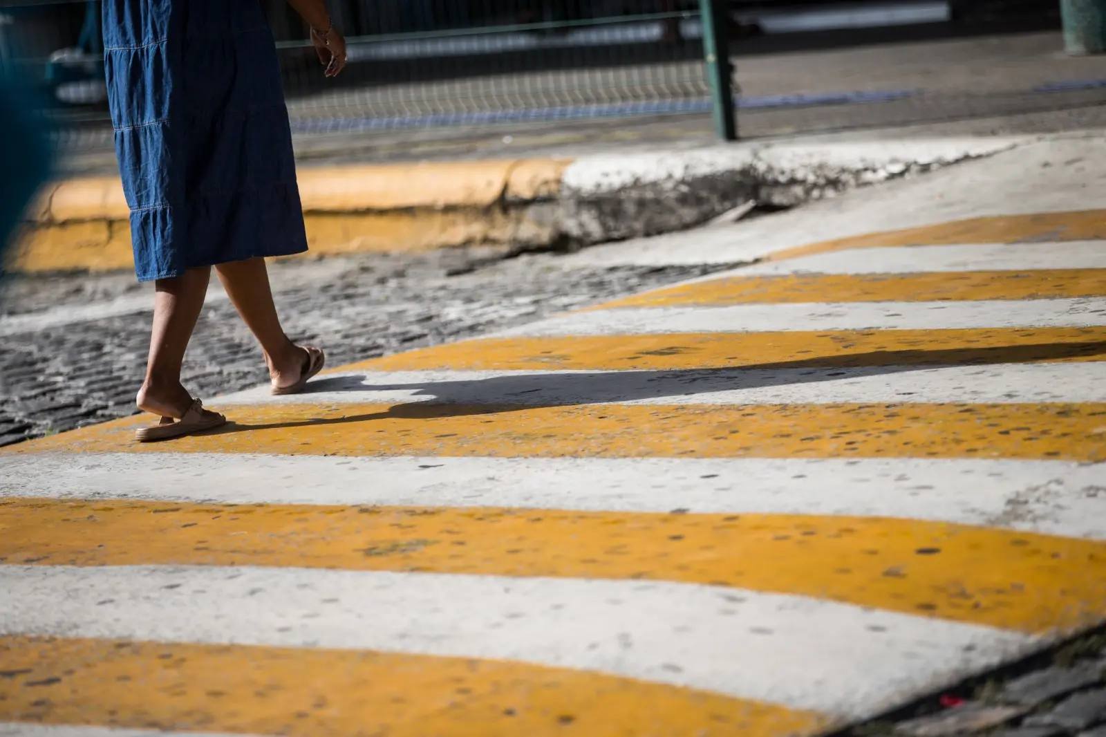foto mulher andando faixa pedestre.