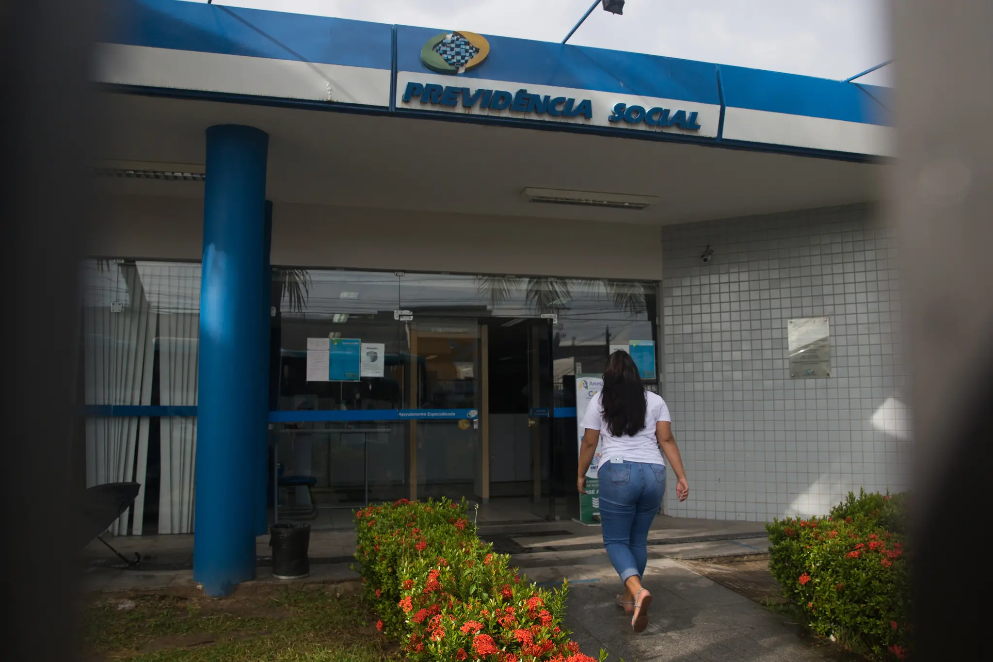 Mulher entrando em agência da previdência social.